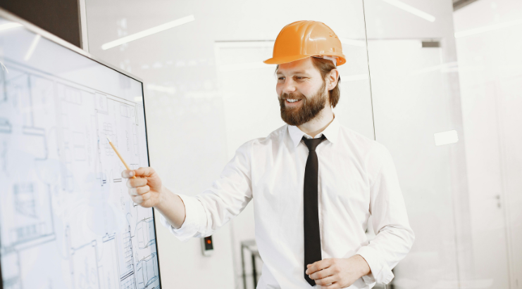Professional with hard hat reviewing documents